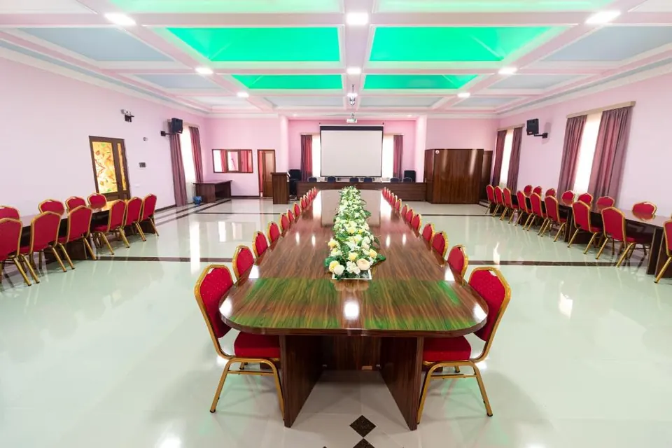 The hall set for a banquet with a long table and flowers