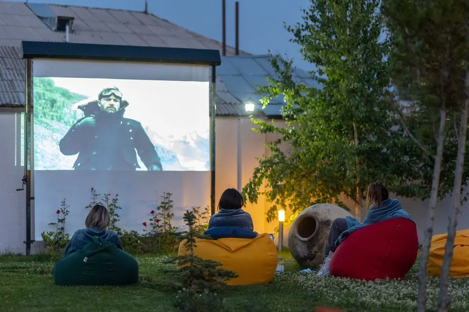 Guests on bean bags watching an open-air film in the hotel garden