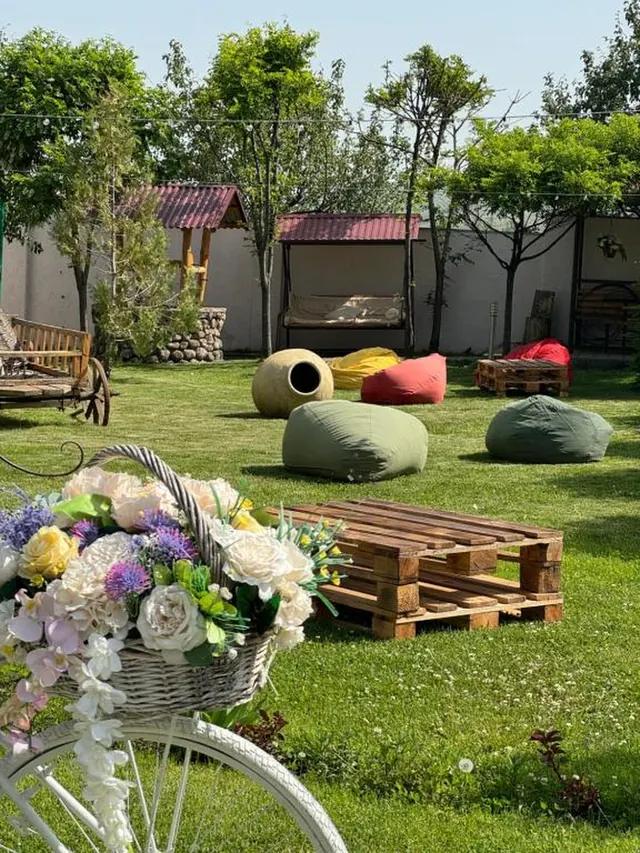 Hotel garden with bean bags, flowers and wooden furniture