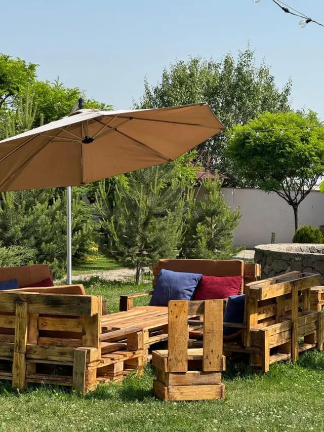 Garden patio with wooden furniture and a parasol