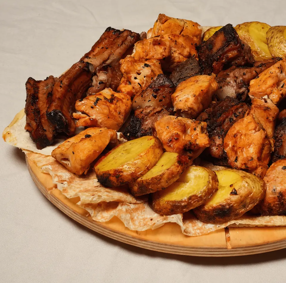 Armenian khorovats barbecue with grilled potatoes on lavash