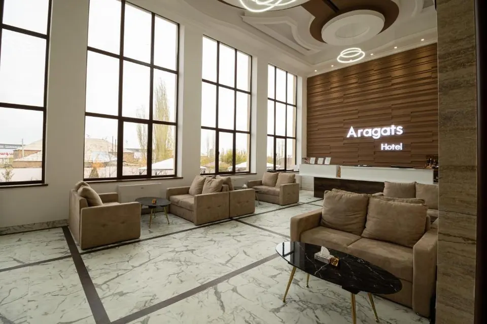 The hotel lobby with sofas, marble floor and wood-panelled walls