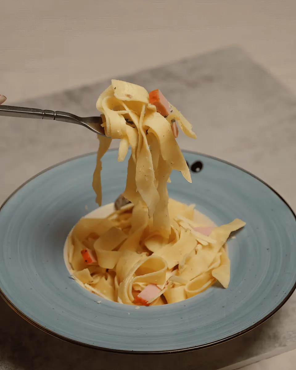 Tagliatelle with creamy sauce twirled on a fork